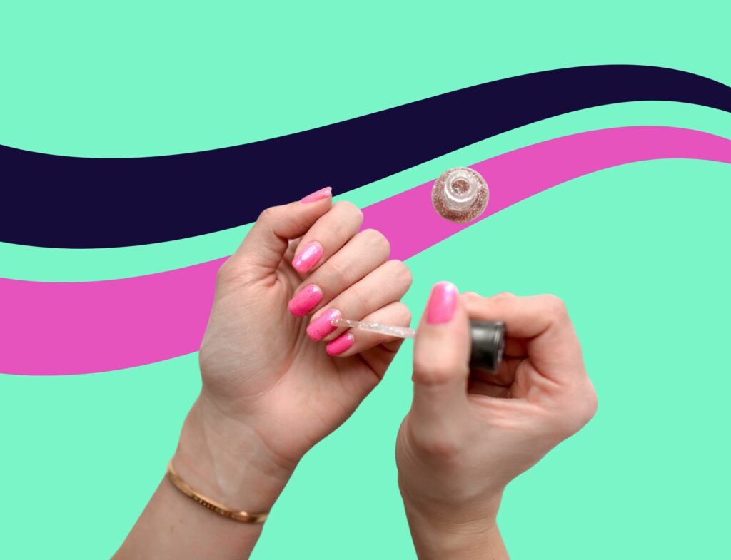 person painting their nails pink in front of colorful background featured in Lyon Content's article about beauty industry news