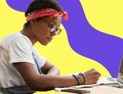 Copywriting vs Content Writing featured image post featuring a young woman sitting at a table writing.