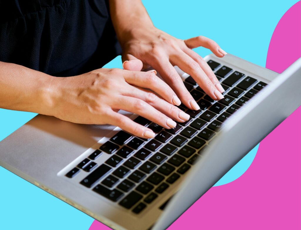 hands typing on laptop keyboard in front of blue and pink background