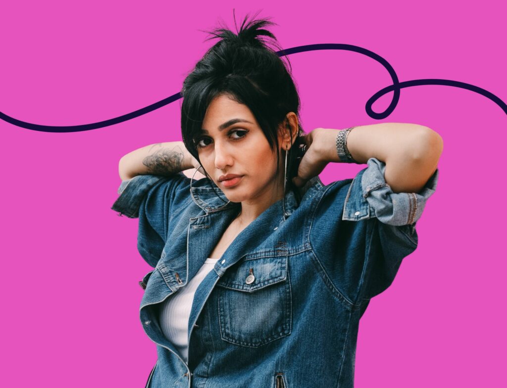 badass woman wearing denim shirt in front of pink background