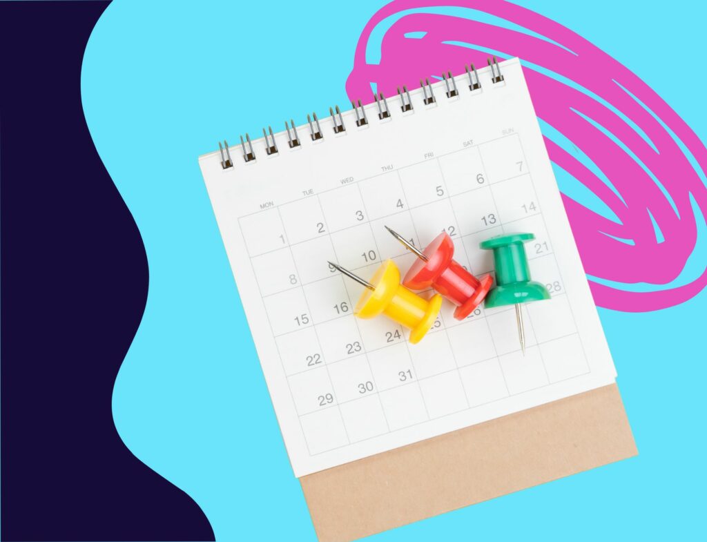 paper calendar for planning content schedule with colored push pins and swirling background 