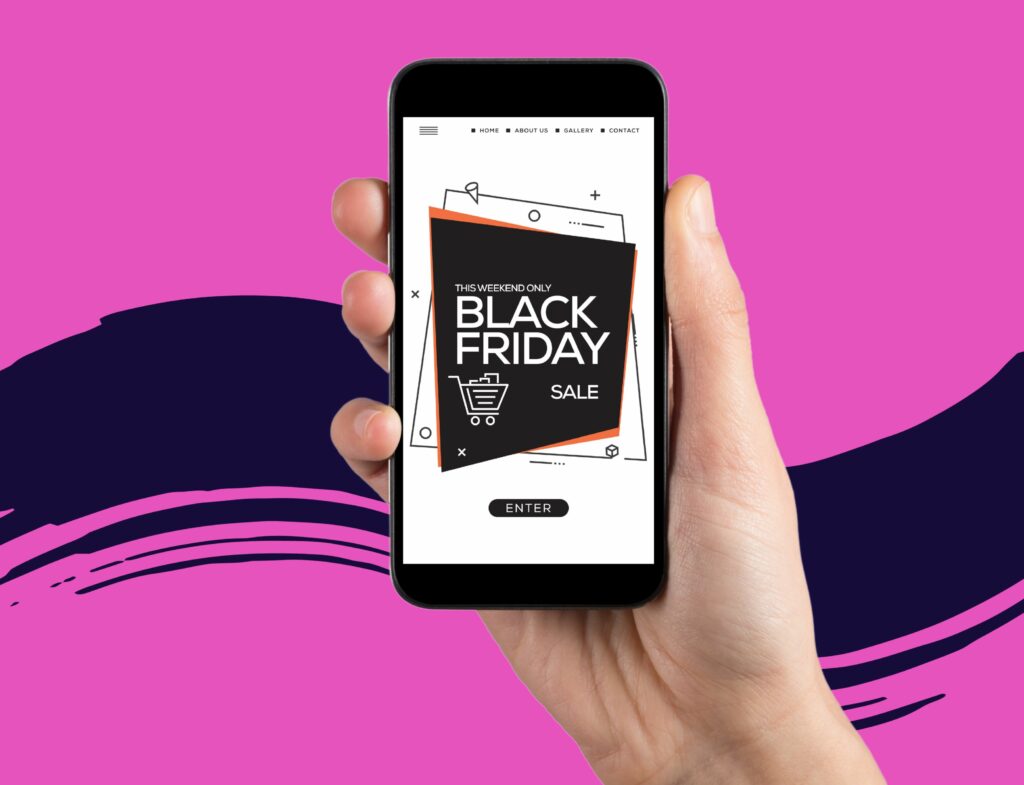 hand holding cell phone displaying black friday marketing graphic in front of pink and navy background