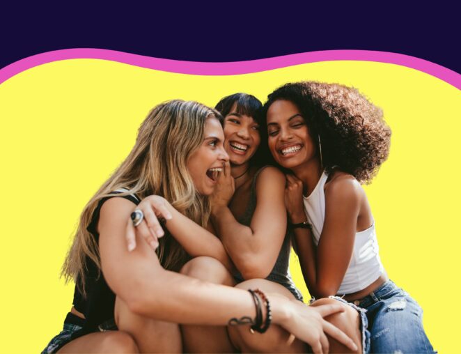 three female friends laugh and hug in front of yellow background for Lyon Content post about defining your audience
