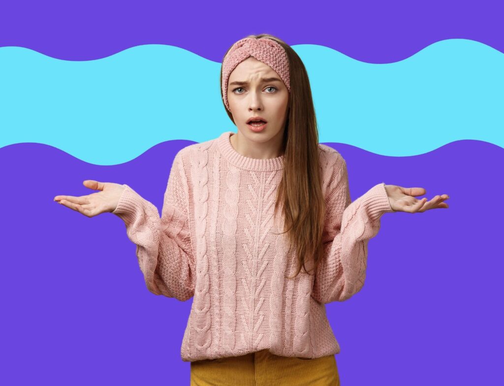 Woman in pink sweater shrugging with confused face in front of blue background to represent lack of focus and SEO on blog