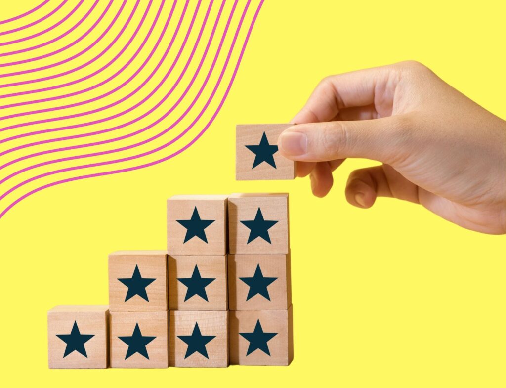 hand stacking increasing star blocks in front of yellow and pink background to represent increasing web traffic with blogging