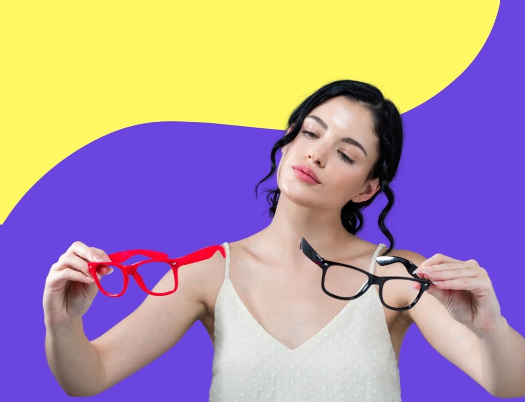 dark haired young woman comparing two types of eye glasses in her hand with colorful background behind her to represent commercial search intent