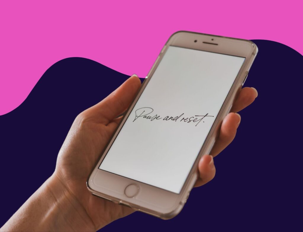 Hand holding an iPhone that says "Pause and refresh" on the screen with blue and pink swirling background