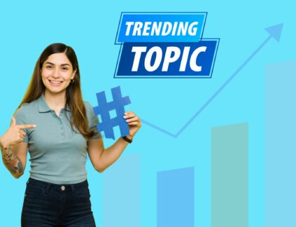 A woman holds a hashtag sign under text that says "trending topics" with a viral chart in the background in this post about how to write about trending topics.